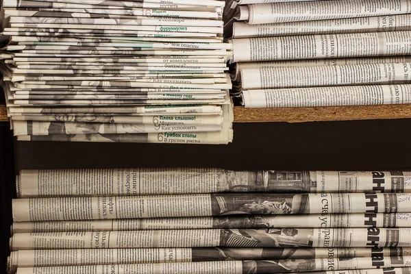 Hromadu starých novin leží na polici — Stock fotografie