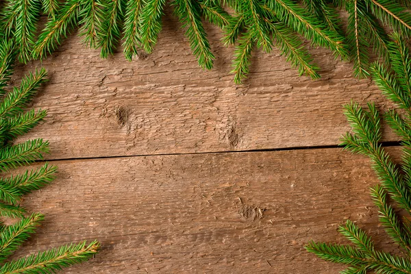 Groene fir takken op een houten achtergrond — Stockfoto