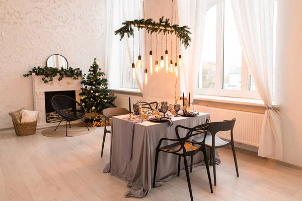 Luxurious expensive light interior in a royal style decorated with table, tree and fireplace