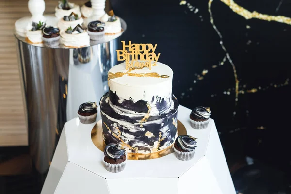 新鲜美味的生日蛋糕 上面印有蜡烛的金盘 白木桌上有纸杯蛋糕的黑白色派 — 图库照片