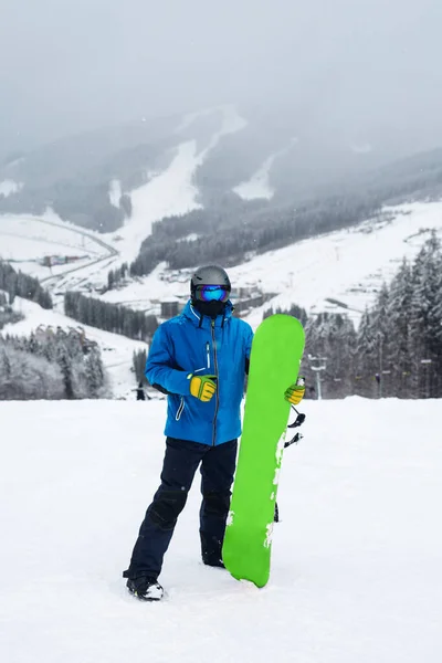 Kışın Bacağının Yanında Yeşil Snowboard Tutan Adam Mavi Ceketli Snowboardcu — Stok fotoğraf