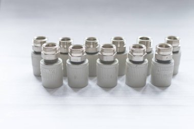Metal ve polipropilen su borularını birleştirmek için birleştirilmiş bağlantılar. Soğuk renklerde izole edilmiş fındıklar