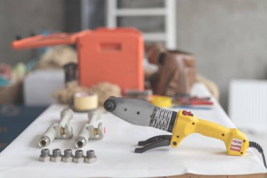 Beyaz masada polipropilen için lehimleme demiri. Isıtma ve su temini için sarı ütünün yan görünümü