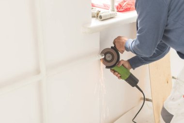 Adam öğütücü kıvılcımlarıyla boru kesiyor. Öğütme makinesi ile çalışma sürecinin yakın plan görüntüsü