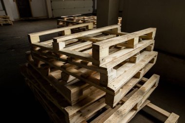 Katlanmış dekoratif şeylerin, işlenmemiş ahşap paletlerin prodüksiyonda kapatılması.