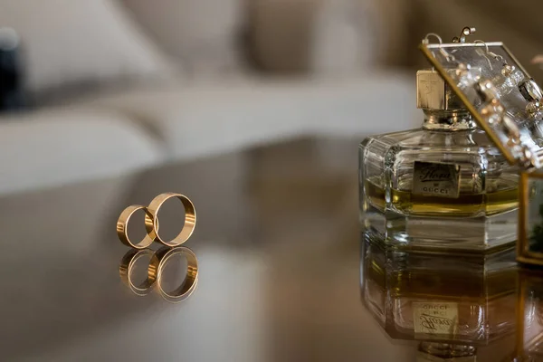 Deux anneaux d'or de mariage sur table miroir avec des parfums marron — Photo