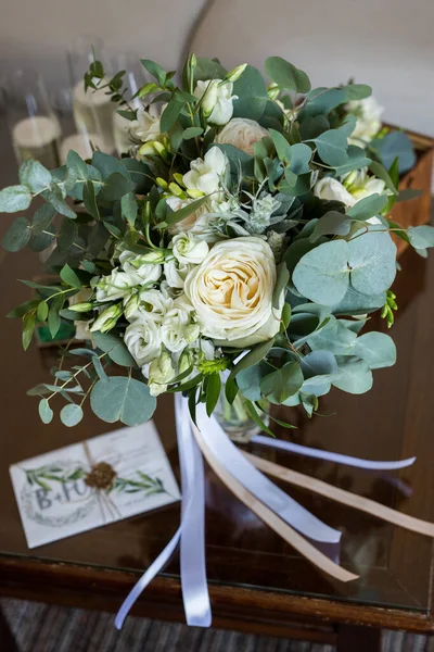 Närbild av vackra anbud bröllop bukett med vita rosor och eustoma blommor på brunt trä bord — Stockfoto