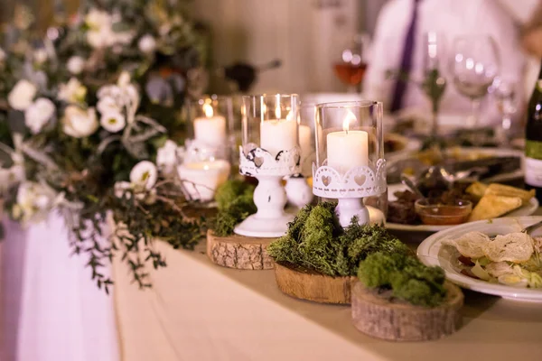 O presidium com arranjo floral com rosa branca fresca, pequenos círculos de madeira com musgo e velas brancas de moda — Fotografia de Stock