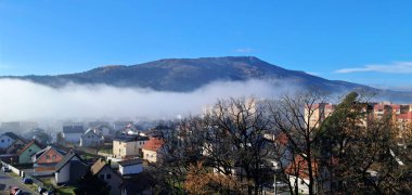 Pohorje dağı ve beyaz sis. Mavi gökyüzü. Şehir Maribor 'u. Slovenya. 