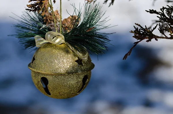 Golden Sleigh Bell Christmas Ornament Decorating an Outdoor Tree