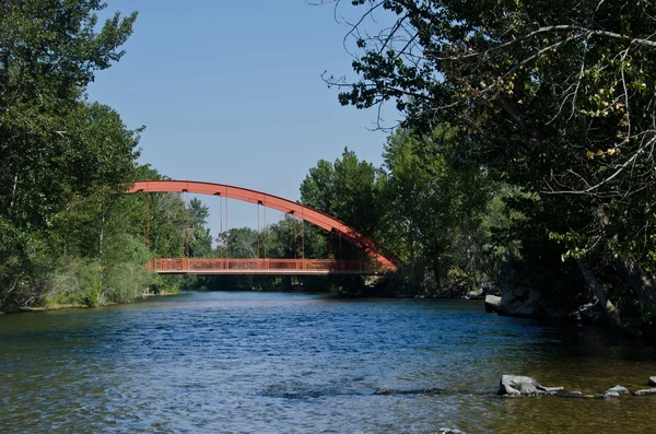 Rode brug over de rivier de uitbreiding — Stockfoto