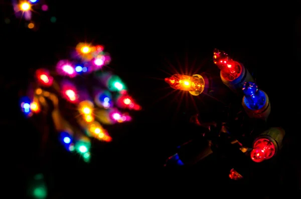 Πολύχρωμο Χριστούγεννα φώτα που λάμπει στο σκοτάδι — Φωτογραφία Αρχείου