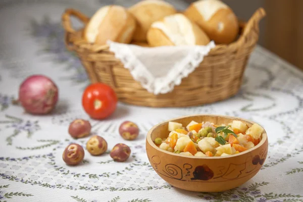 Comida tradicional peruana Matasquita con verduras crudas y canasta de pan —  Fotos de Stock