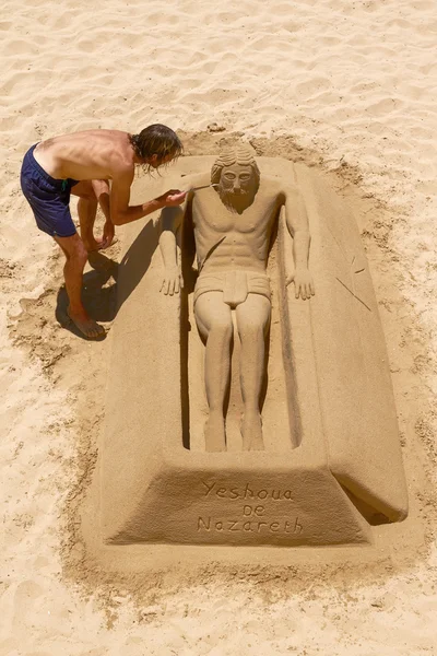 Jeune homme travaillant sur la sculpture de sable de Jésus à Cadix, Espagne — Photo