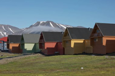 Longyearbyen Svalbard 'da güneşli bir günde geleneksel renkli ahşap evler.