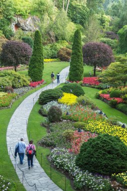 People walking through park in Butchart Gardens clipart