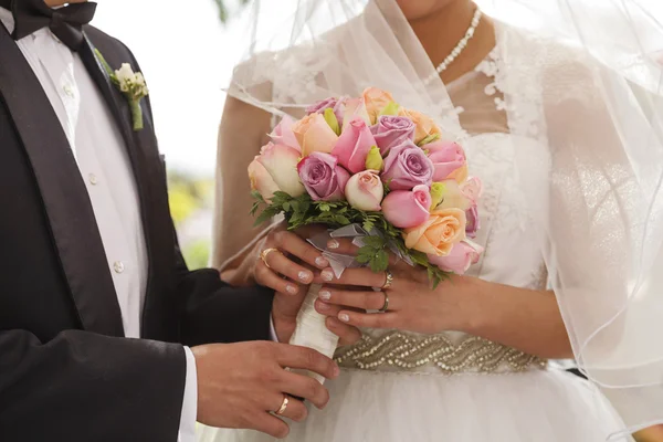 Brud- och brudgummen håller varandra i handen — Stockfoto