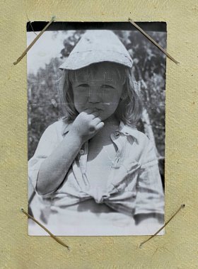 Eski bir albümde küçük bir kızın retro fotoğrafı, geçmiş, hatıralar.