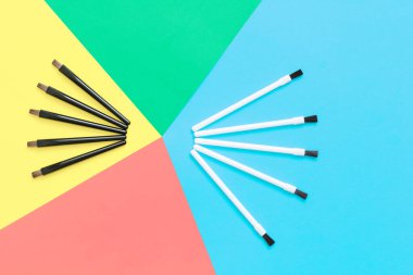 Renkli bir arka planda makyaj fırçası seti. Makyöz stilistinin moda aksesuarları. Pastel tonlarda gökkuşağı renkleri. Doğal fırçalar siyah ve beyazdır..