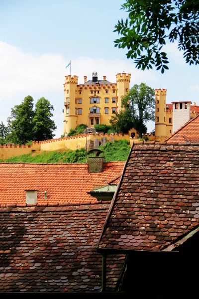 Schloss Hohenschwangau castle against the sky with clouds. Rustic tiled roofs. Upper Swan County Palace near Fussen in Bavaria, Germany. Residence of King Ludwig II.