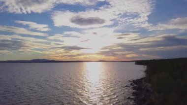 Murmansk bölgesinde gün batımı, Rusya 'nın geniş alanları büyüleyici ve etkileyici boyutlarda, Murmansk bölgesindeki Rus Imandra gölünün üzerinde uçan insansız hava aracı, bulutlar ve ağaçlar o kadar güzel ki gözlerinizi hayret verici boyuttan ayırmanız imkansız.