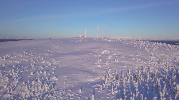 Antena de estação base celular gelada coberta de neve. Torre do local do telemóvel na moutain. Transceptores de rede telefônica e equipamentos de comunicação no dia gelado após a tempestade de neve. Céu azul — Vídeo de Stock