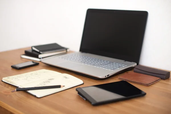 Escritório local de trabalho com laptop, telefone inteligente e notebook na mesa de madeira — Fotografia de Stock