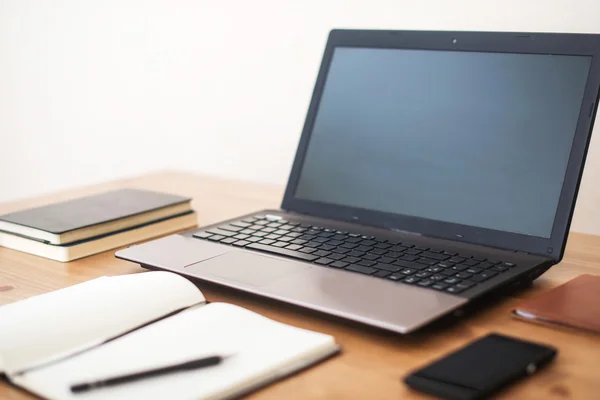 Escritório local de trabalho com laptop, telefone inteligente e notebook na mesa de madeira — Fotografia de Stock