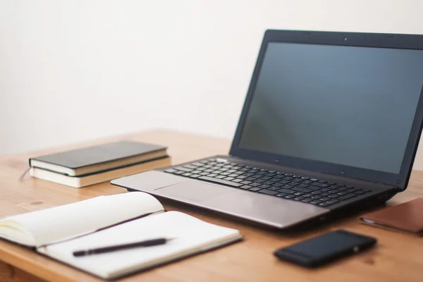 Escritório local de trabalho com laptop, telefone inteligente e notebook na mesa de madeira — Fotografia de Stock