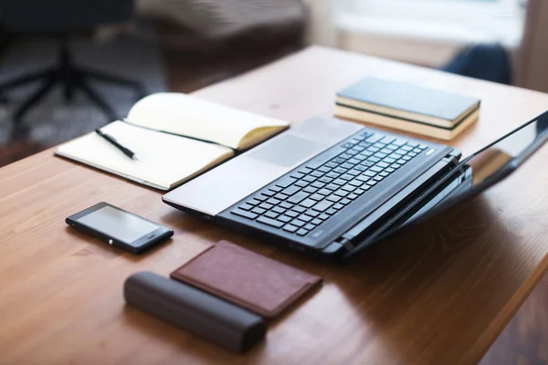 ノート パソコン、スマート フォン、木製のテーブルの上のノートを仕事場 — ストック写真