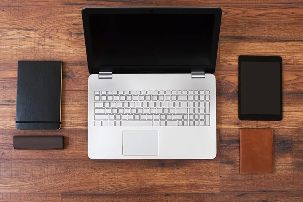 Escritório local de trabalho com laptop, telefone inteligente e notebook na mesa de madeira — Fotografia de Stock