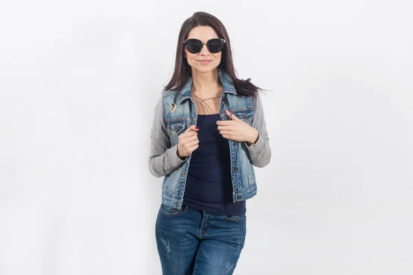 Woman posing in jeans on white wall — Stock Photo, Image