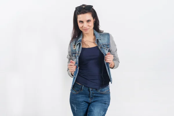 Vrouw poseren in jeans op de witte muur — Stockfoto