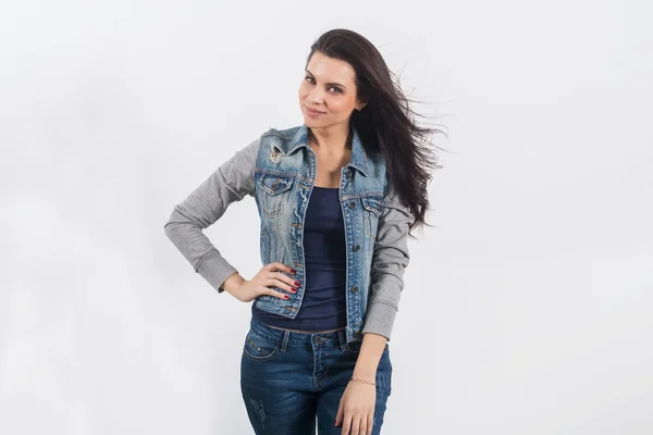 Vrouw poseren in jeans op de witte muur — Stockfoto