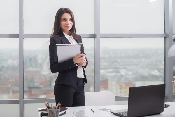 Femme d'affaires avec ordinateur portable est fenêtre dans le bureau — Photo