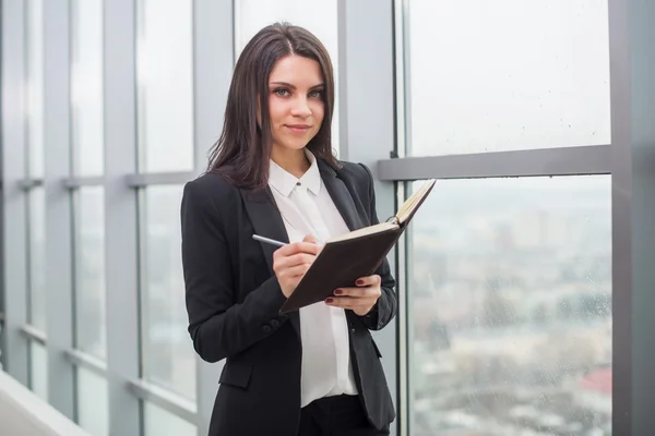 Femme d'affaires avec ordinateur portable est fenêtre dans le bureau — Photo