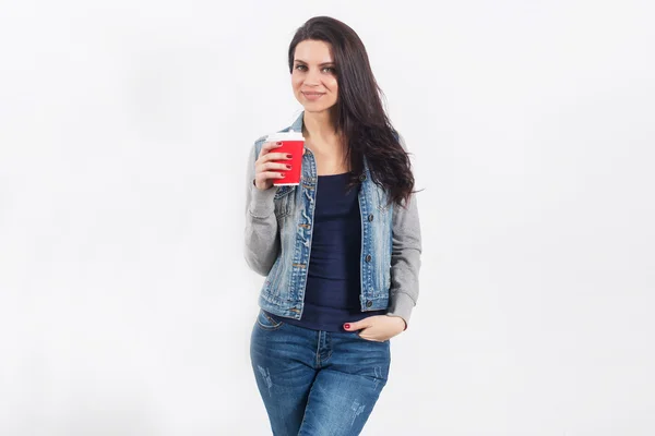 Женщина на белой стене с кофе на вынос — стоковое фото