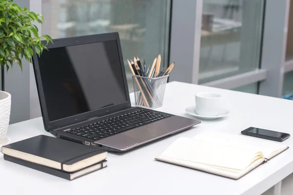 Escritório local de trabalho com notebook sobre mesa de madeira — Fotografia de Stock