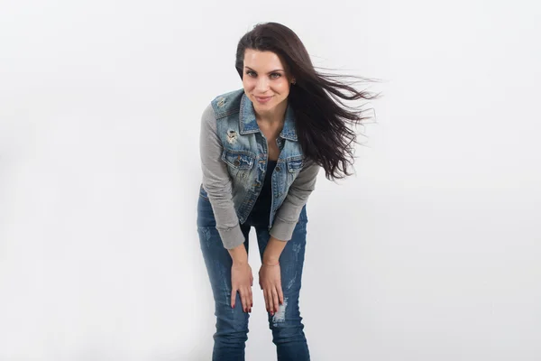 Woman posing in jeans on white wall — Stock Photo, Image