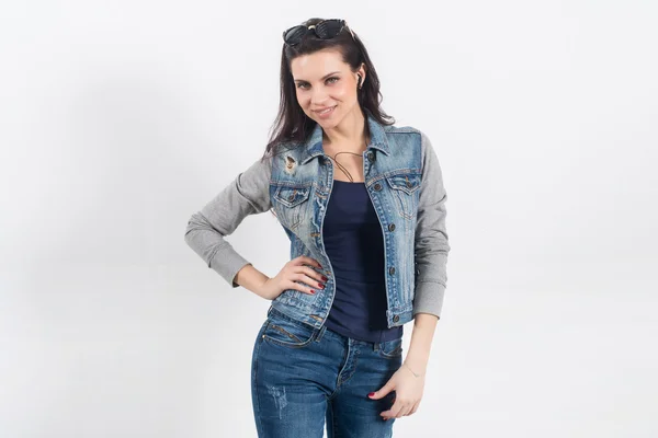 Vrouw poseren in jeans op de witte muur — Stockfoto