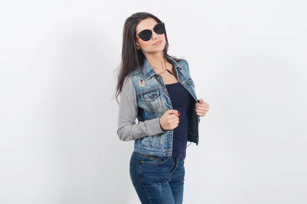 Woman posing in jeans on white wall — Stock Photo, Image