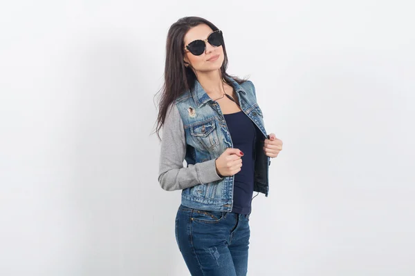 Vrouw poseren in jeans op de witte muur — Stockfoto