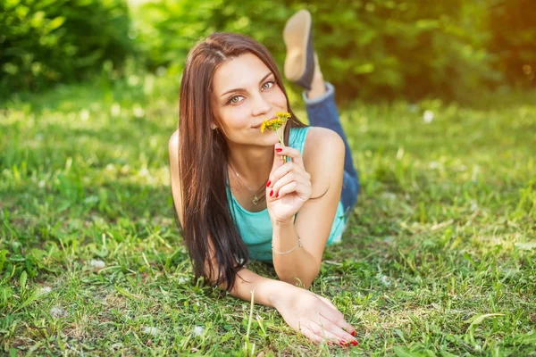 Hermosa mujer relajándose al aire libre en la hierba mirando feliz y sonriente . — Foto de Stock