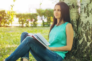 Otların arasında oturan kız yaz güneş ışığı kitap okuma