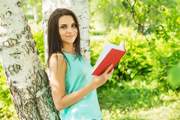 Fille dans vert parc lire livre en été soleil ligh — Photo