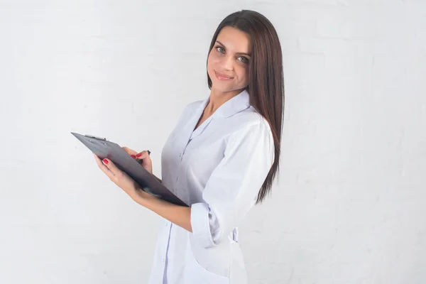 Portrait de femme médecin au couloir de l'hôpital, tenant un ordinateur tablette, regardant la caméra, souriant. — Photo