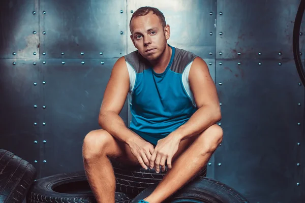 Um desportista sentado na máquina dos pneus. Conceito de CrossFit, saúde e força . — Fotografia de Stock