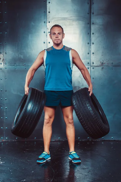 运动员。适合男性教练的人保持汽车轮胎、 概念运动量来找到健身锻炼实力电源 — 图库照片