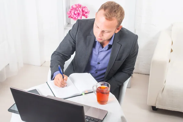 Homme d'affaires au bureau assis à table avec un ordinateur portable écrit concentration — Photo