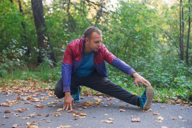 spor adamı park sonbahar germe egzersizleri yapıyor. Fitness kavramları